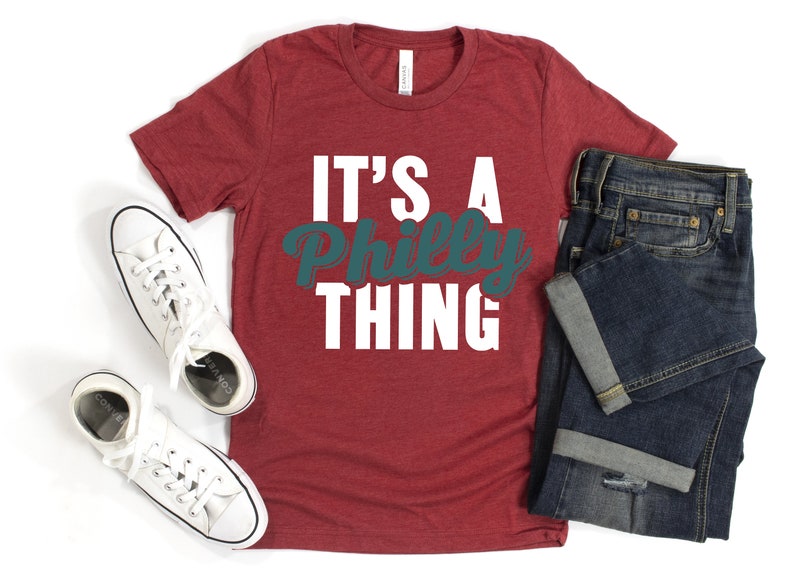 May include: Red t-shirt with the text "It's a Philly Thing" in white and teal lettering.