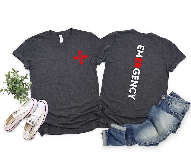 May include: Two dark gray t-shirts with a red plus sign on one and the word "EMERGENCY" vertically down the back of the other.