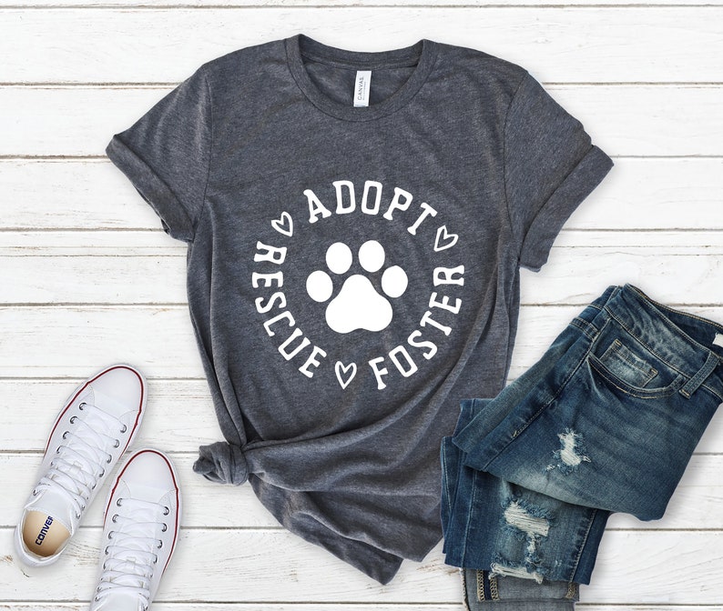 May include: A heather grey t-shirt with a white paw print and the text "Rescue Adopt Foster" in a circle around the paw print.