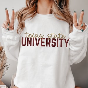 May include: White sweatshirt with the text "texas state UNIVERSITY" in maroon and gold lettering.