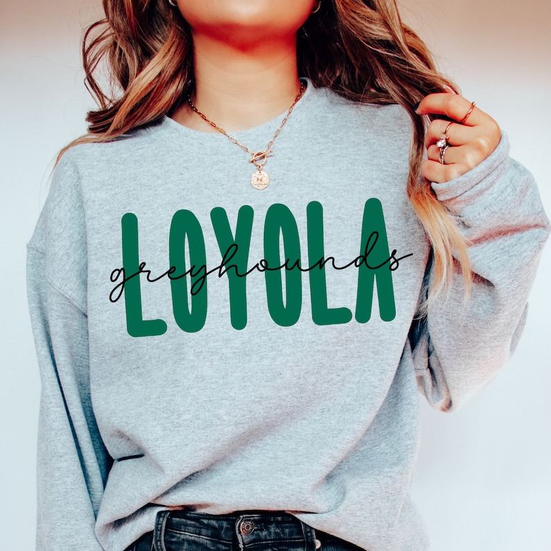 Pode incluir: Uma camisa de moletom cinza com o texto "LOYOLA" em letras verdes e "greyhounds" em escrita cursiva preta abaixo.