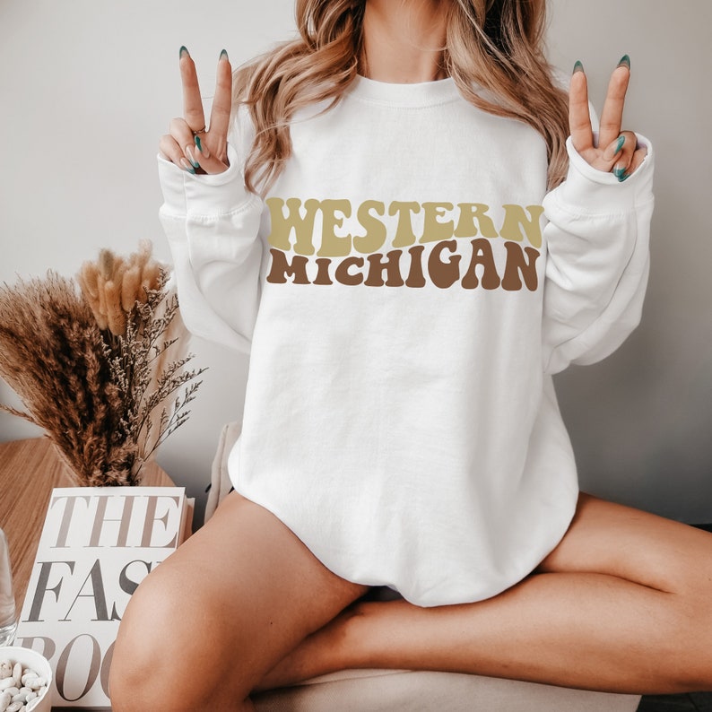 May include: A white sweatshirt with the text "WESTERN MICHIGAN" in brown and gold retro lettering.