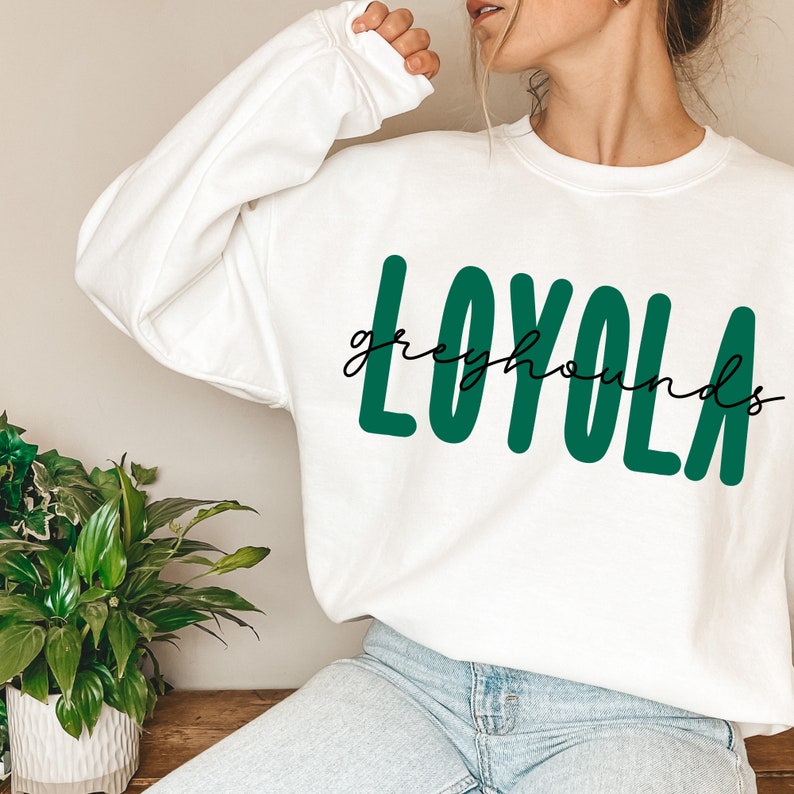 Pode incluir: Camisola branca com texto verde que diz "LOYOLA greyhounds".