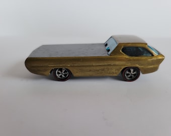May include: A gold toy pickup truck with a flatbed and a rear window. The truck has black wheels with silver hubcaps.