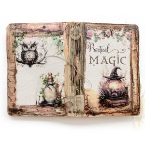 Może przedstawiać: Otwarta książka z napisem "Practical Magic" i ilustracjami sowy, butelki z eliksirem i kryształowej kuli z kapeluszem czarownicy. Książka ma wygląd vintage, z kwiatowymi i botanicznymi akcentami.