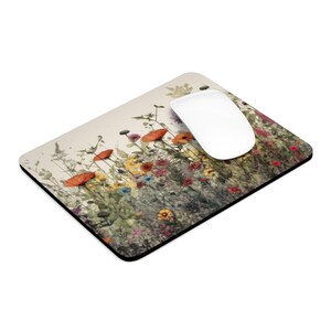May include: A colorful floral mousepad with a watercolor design of a field of wildflowers in shades of red, orange, yellow, and green. The mousepad is rectangular and has a black border.