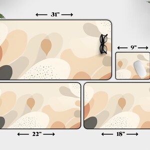 May include: Set of four desk mats with an abstract design featuring beige, brown, and gray colors. The largest mat measures 31 inches by 15.5 inches, the second largest measures 22 inches by 12 inches, the third largest measures 18 inches by 12 inches, and the smallest measures 9 inches by 7 inches.
