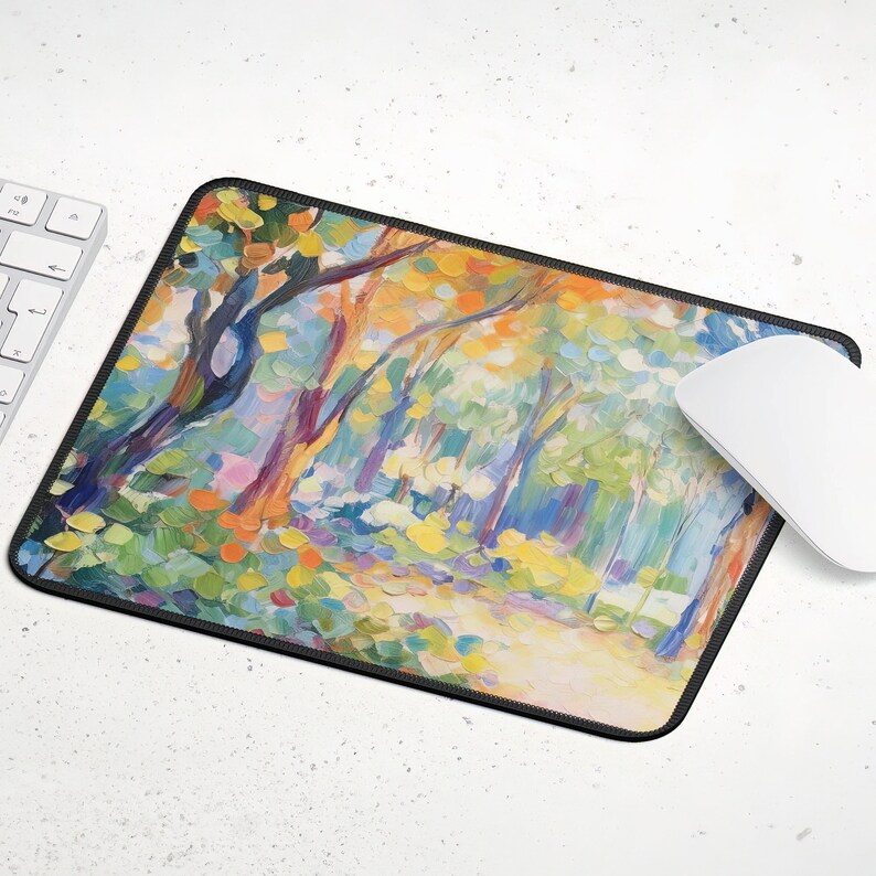 May include: A colorful abstract painting of a forest scene with trees and a path. The painting is on a black mouse pad with a stitched edge.