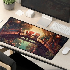 Pu&ograve; includere: Un tappetino per mouse nero e verde con un'illustrazione fantasiosa di due gatti seduti su un ponte in un ambiente boschivo. I gatti sono rossi e arancioni con accenti bianchi. Lo sfondo &egrave; una foresta verde scuro con un fiume blu e un cielo al tramonto.