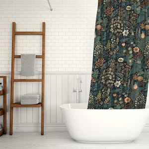 May include: A white bathtub with a shower curtain featuring a dark blue and green floral pattern. The shower curtain has a variety of flowers and leaves in shades of orange, yellow, and white. The bathroom has white subway tile walls and a wooden ladder shelf.