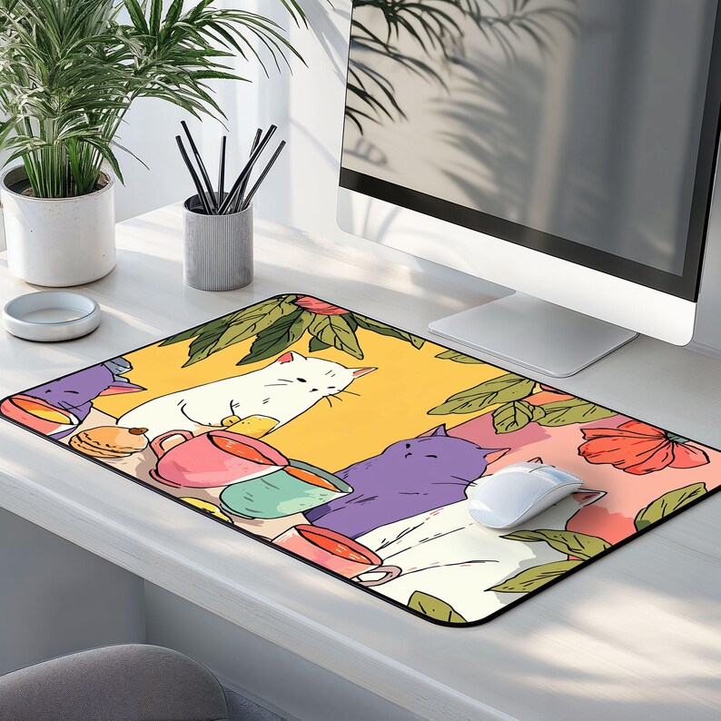 Peut inclure: Tapis de souris rectangulaire avec une illustration fantaisiste de chats, de tasses &agrave; th&eacute; et d'&eacute;l&eacute;ments floraux. Le motif comprend un chat blanc, un chat violet et diverses tasses color&eacute;es sur fond jaune et rose. Une souris d'ordinateur blanche repose sur le tapis.