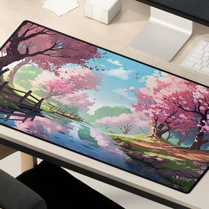 May include: A black mousepad with a colorful illustration of a Japanese garden scene. The scene features a winding river, a wooden bridge, and pink cherry blossom trees.