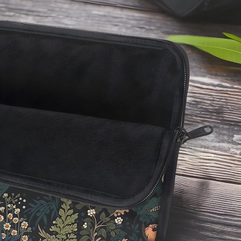 Pode incluir: Uma capa para laptop preta com fecho de correr. A capa &eacute; forrada com um fleece preto macio e tem um padr&atilde;o floral no exterior.