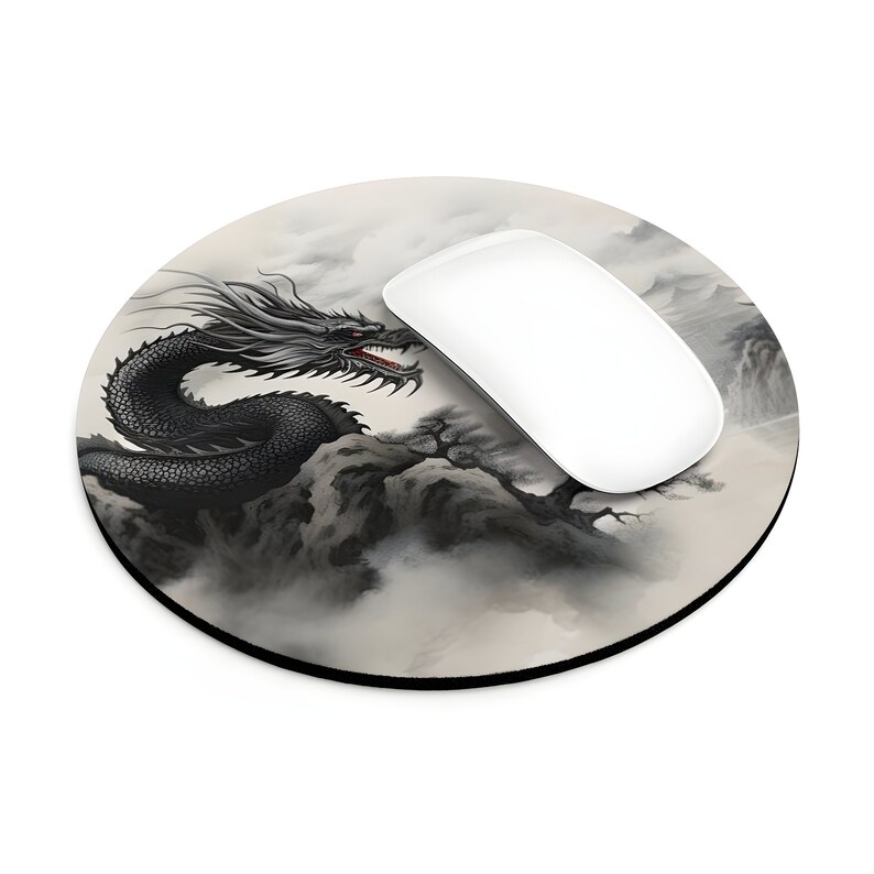 May include: A round mouse pad with a black dragon in a gray and white mountain landscape. The dragon is facing the right side of the image. The mouse pad is on a white background.