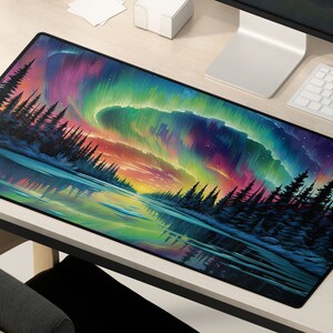 May include: A colorful mousepad with a vibrant aurora borealis scene over a dark forest. The aurora is a mix of pink, purple, green, and blue, with a reflection of the lights in the water below.