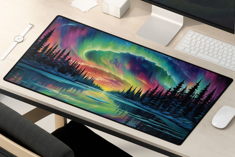 May include: A colorful mousepad with a vibrant aurora borealis scene over a dark forest. The aurora is a mix of pink, purple, green, and blue, with a reflection of the lights in the water below.