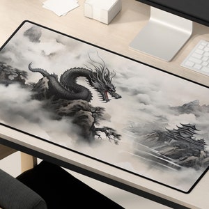May include: A black and white mousepad with a dragon and mountain scene. The dragon is flying through the clouds and the mountains are in the background.