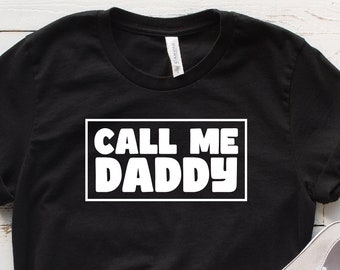 May include: Black t-shirt with white text that says "CALL ME DADDY" in a bold, rectangular box.