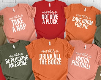May include: Ten different t-shirts with funny Thanksgiving-themed sayings. The shirts are in various colors, including red, orange, green, and brown. The sayings include "most likely to rule the kids table", "most likely to take a nap", "most likely to not give a pluck", "most likely to save room for pie", "most likely to carve the turkey", "most likely to be plucking awesome", "most likely to drink all the booze", "most likely to watch football", "most likely to be a cutie pie", and "most likely to follow tradition".