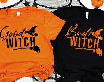 May include: Two t-shirts, one orange and one black, with the text "Good Witch" and "Bad Witch" in black lettering. Each shirt features a witch's hat and a broom.