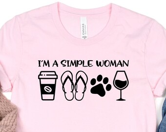 May include: Pink t-shirt with the text "I'm a simple woman" and icons of coffee, flip flops, a paw print, and a glass of wine.