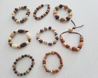 Puede incluir: Ocho pulseras de madera en varios tonos de marrón, beige y crema. Algunas pulseras tienen un cierre de cuerda, mientras que otras tienen un cierre de metal. Las pulseras están hechas de cuentas redondas, ovaladas y cuadradas.