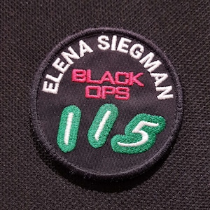 Op de afbeelding: Een witte keramische mok met een zwart handvat en de tekst "But First, Coffee" in een zwarte, handgeschreven lettertype. De mok staat op een wit oppervlak.