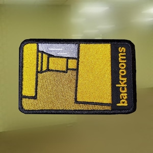 May include: Embroidered patch with a yellow and brown geometric design and a black border. The patch features the word "backrooms" in yellow text on a black vertical stripe. The design resembles a maze or interior space.