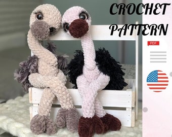 May include: Crochet pattern for two amigurumi ostriches, one with brown and gray feathers and the other with pink and black feathers. The ostriches are sitting on a white wooden crate. The pattern is available as a PDF download. The image also includes the text "CROCHET PATTERN" and a US flag.