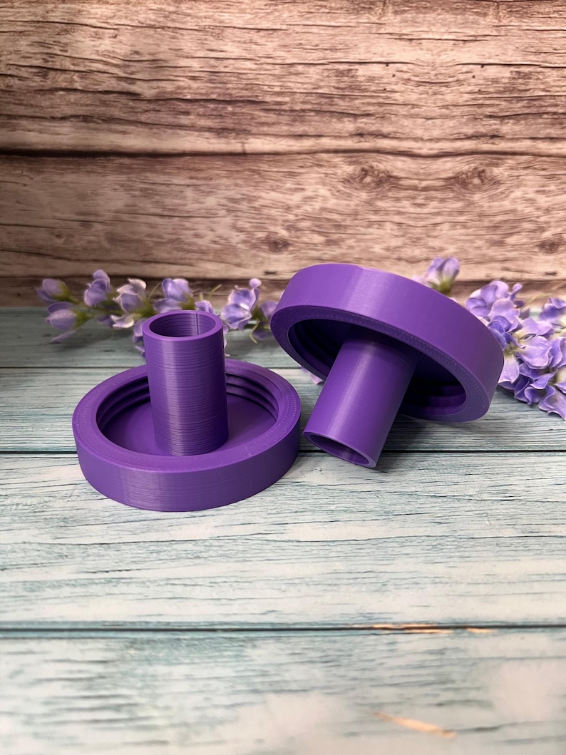 Peut inclure: Deux bougeoirs en plastique violet de forme cylindrique. Les bougeoirs ont une l&egrave;vre sur&eacute;lev&eacute;e autour du haut et du bas.