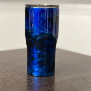 May include: A blue and black marbled stainless steel tumbler with a silver lid.