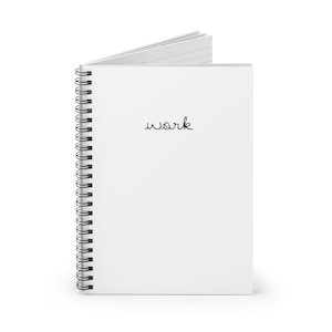Puede incluir: Un cuaderno blanco de espiral con la palabra "work" escrita en la portada.
