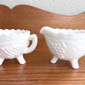 May include: A set of three ceramic mugs with a speckled, matte finish. The mugs are in shades of cream, light gray, and dark gray. Each mug has a simple, minimalist design, perfect for coffee or tea.