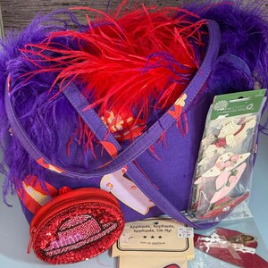 Gloednieuwe Red Hat Society-tas met aangehechte paarse verenboa, portemonneetje met pailletten, applicaties voor hoge hakken en een complete set knutselaccessoires.