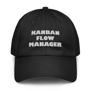 May include: Black baseball cap with the white embroidered text "KANBAN FLOW MANAGER" across the front. The cap has a curved brim and an adjustable strap at the back.