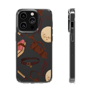 May include: A clear phone case with a black background and a colorful pattern of books, belts, and moons. The case is designed for a phone with a triple lens camera.
