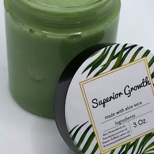 Puede incluir: Un tarro verde con una etiqueta blanca que dice "Superior Growth made with aloe vera" y enumera los ingredientes: Aloe Vera, aceite mineral, vaselina, aceite de coco, vitamina A, aceite de ricino negro, lanolina de mentol de romero. El tarro est&aacute; etiquetado con un tama&ntilde;o de 3 oz.
