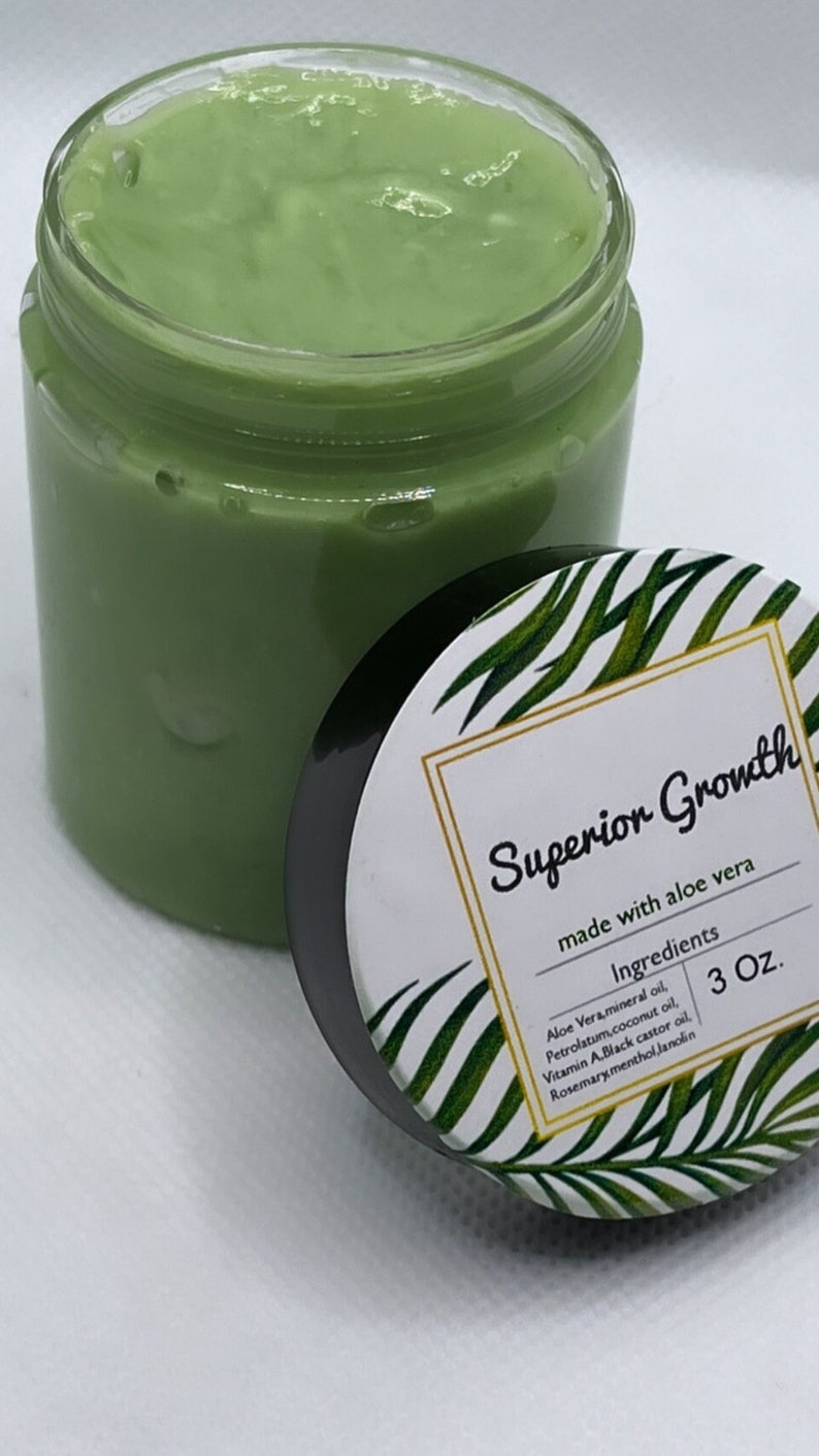 Puede incluir: Un tarro verde con una etiqueta blanca que dice "Superior Growth made with aloe vera" y enumera los ingredientes: Aloe Vera, aceite mineral, vaselina, aceite de coco, vitamina A, aceite de ricino negro, lanolina de mentol de romero. El tarro est&aacute; etiquetado con un tama&ntilde;o de 3 oz.