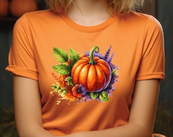 May include: Orange t-shirt with a colorful illustration of a pumpkin with green leaves and purple flowers.