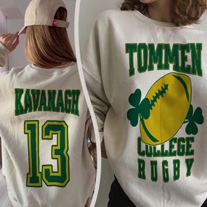 May include: Cream-colored sweatshirt with green and yellow lettering and graphics. One sweatshirt features the name "KAVANAGH" and the number "13". The other displays "TOMMEN COLLEGE RUGBY" with a rugby ball and shamrocks.