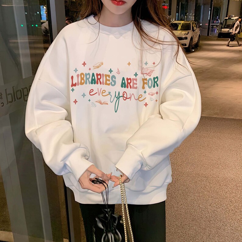 May include: White sweatshirt with a colorful graphic that says "Libraries are for everyone" with stars and other illustrations.