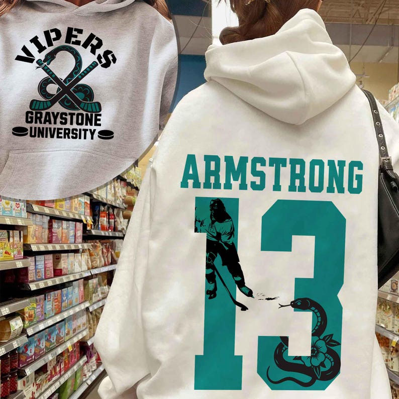 May include: White hoodie with the text "VIPERS" and "GRAYSTONE UNIVERSITY" in black and teal. The back of the hoodie features the name "ARMSTRONG" and the number "13" in teal, along with a snake graphic.