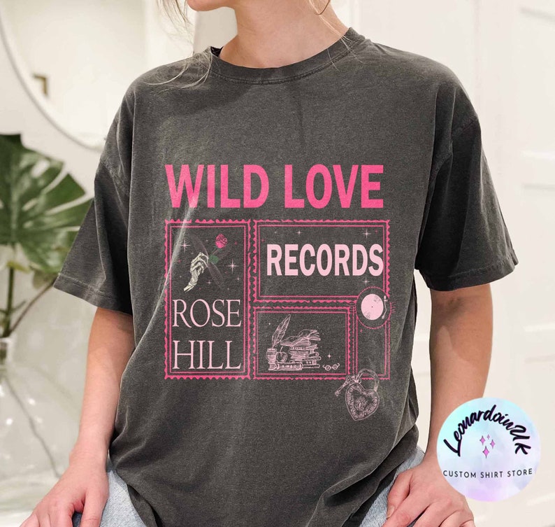 May include: A black t-shirt with a pink graphic design that says "Wild Love Records" with a smaller graphic that says "Rose Hill".