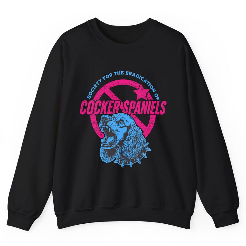 May include: Black sweatshirt with a graphic featuring a blue Cocker Spaniel with an open mouth and a spiked collar. The design includes the text "SOCIETY FOR THE ERADICATION OF COCKER SPANIELS" in pink and blue.