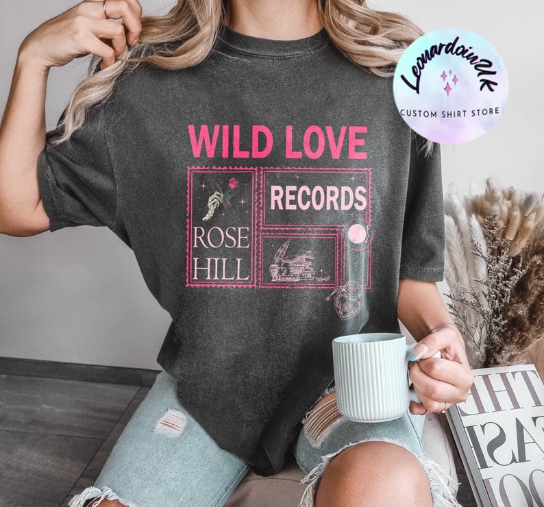 May include: A black t-shirt with a pink graphic design that says "WILD LOVE RECORDS" and "ROSE HILL".