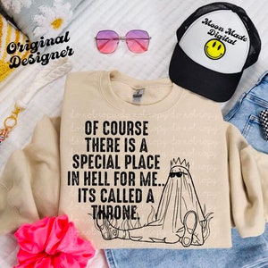 May include: A beige sweatshirt with a black graphic print that says "Of course there is a special place in hell for me... It's called a throne." The graphic features a ghost wearing a crown and sunglasses sitting on a throne of flames.