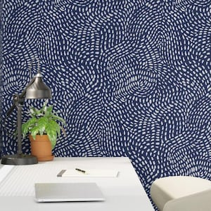 May include: Navy blue wallpaper with a repeating pattern of white, dotted lines. The design creates a swirling, textured effect. The wallpaper covers the wall and a portion of the desk, creating a cohesive look. A desk lamp and potted plant are visible.