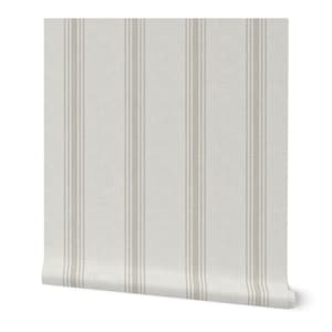 May include: A roll of wallpaper with a vertical striped pattern. The stripes alternate between a light beige and a slightly darker beige, creating a subtle contrast against the off-white background. The wallpaper has a textured appearance.