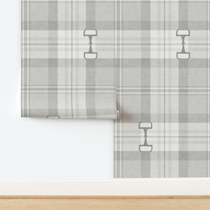 May include: Gray and white plaid wallpaper with a repeating pattern of equestrian bits. The wallpaper is partially rolled out, revealing the pattern. The design features a classic plaid pattern with a subtle texture, suitable for interior decor.