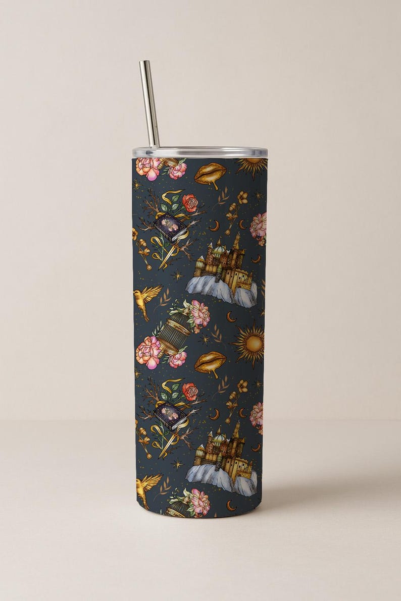 May include: A stainless steel tumbler with a whimsical pattern of castles, birds, flowers, and celestial elements in shades of gold, pink, and blue. The design is set against a dark blue background. Includes a silver straw.